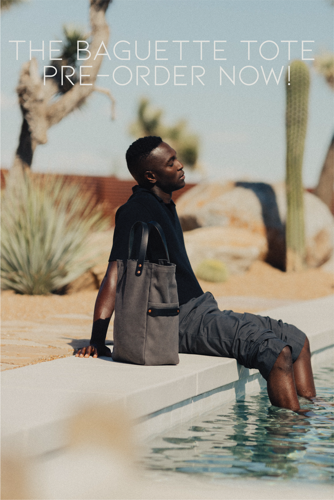 A man sits on the edge of a pool with a leather-handled canvas tote next to him