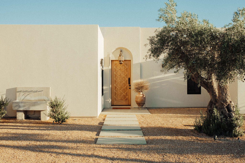 A stucco single level home with clean straight lines and an ornate door