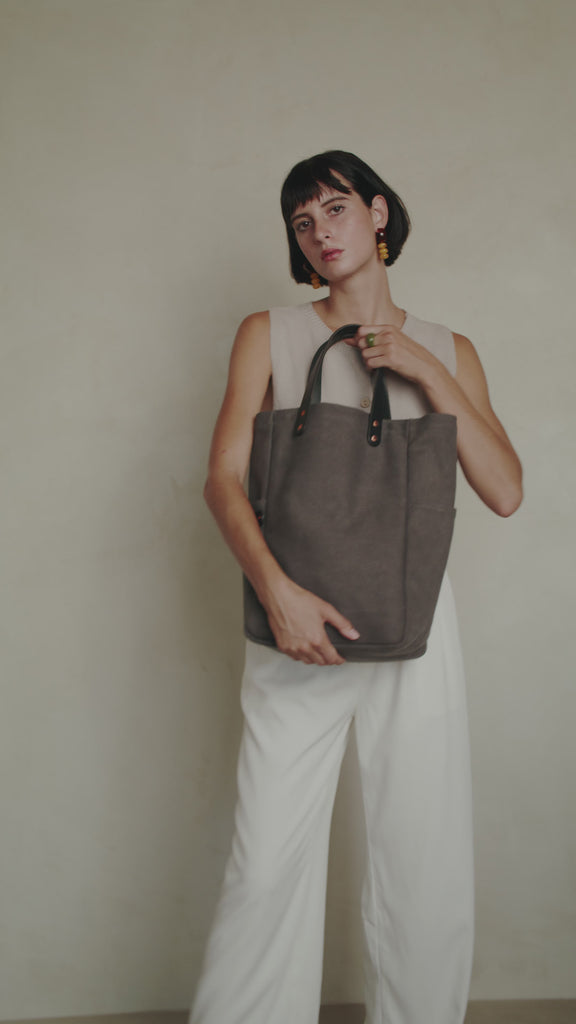 Video of a woman holding a leather-handled canvas tote in smoke